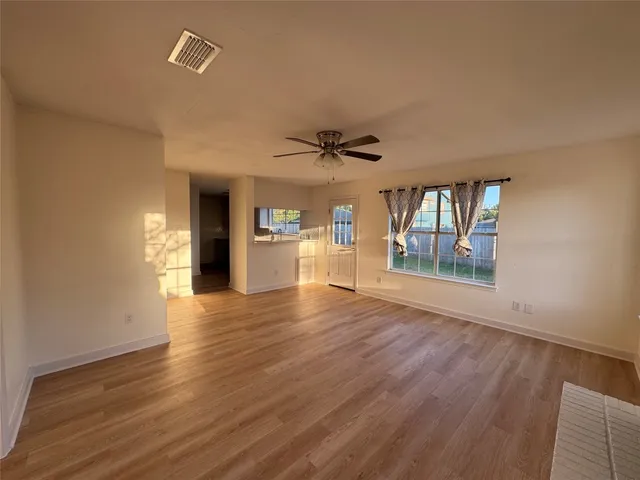 a view of an empty room with a fireplace and a window