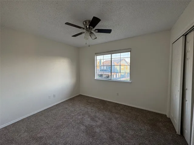 an empty room with windows and fan
