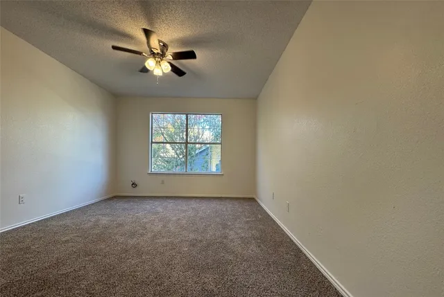 a view of an empty room with a ceiling fan
