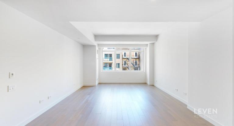 305 East 51st Street, Unit RU5A Manhattan, NY 10022 - Photo 2 of 15 an empty room with wooden floor and windows