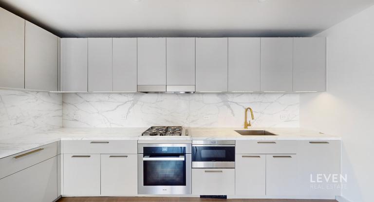 305 East 51st Street, Unit RU5A Manhattan, NY 10022 - Photo 7 of 15 a kitchen with cabinets appliances and a sink