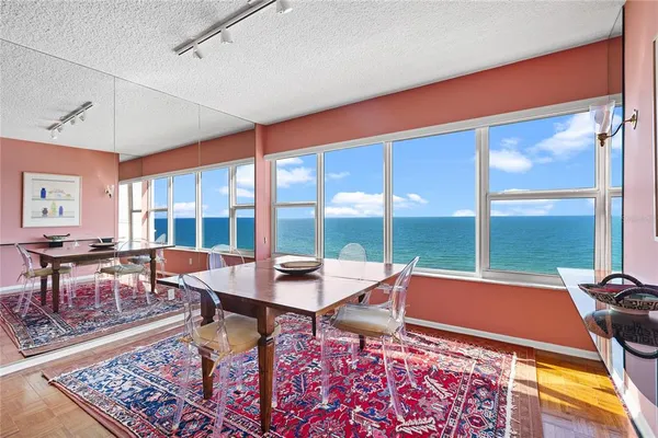 a living room with furniture a rug and a floor to ceiling window