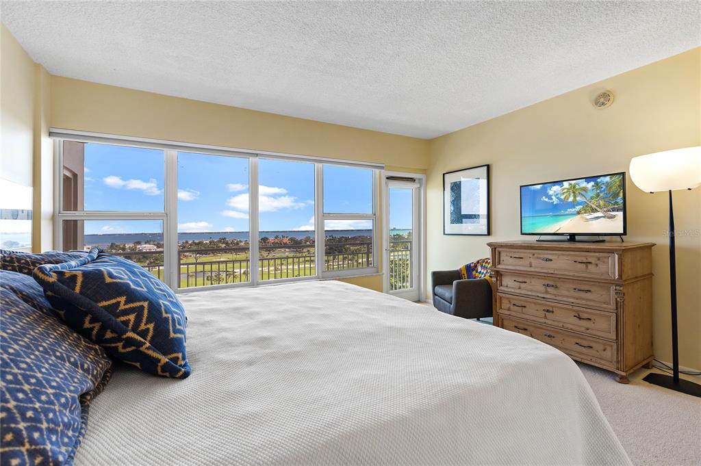 Undisclosed Address Longboat Key, FL 34228 - Photo 17 of 68 a spacious bedroom with a bed and large windows