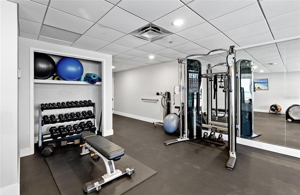 601 Longboat Club Road, Unit 902S Longboat Key, FL 34228 - Photo 40 of 65 a room with gym equipment and a flat screen tv