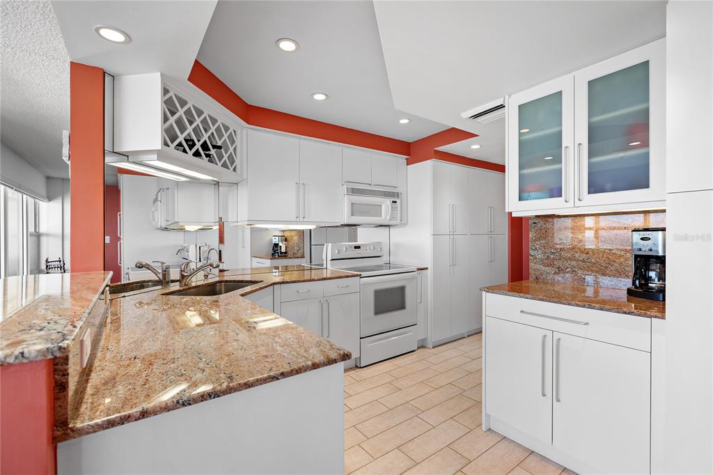 601 Longboat Club Road, Unit 902S Longboat Key, FL 34228 - Photo 5 of 65 a kitchen with white cabinets and appliances