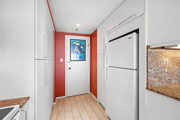 a hallway with a large window and kitchen
