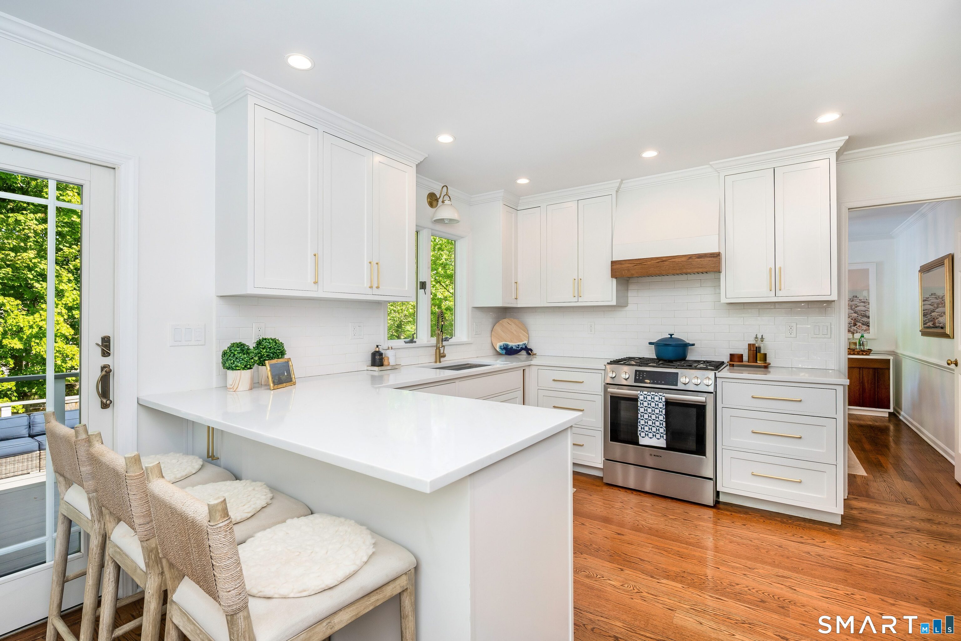 27 Point O Woods Road South Darien, CT 06820 - Photo 6 of 32 a kitchen with stainless steel appliances granite countertop a stove a sink a microwave a refrigerator white cabinets and wooden floor
