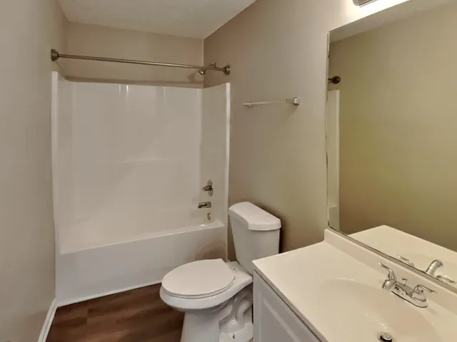 a white toilet sitting next to a bath tub