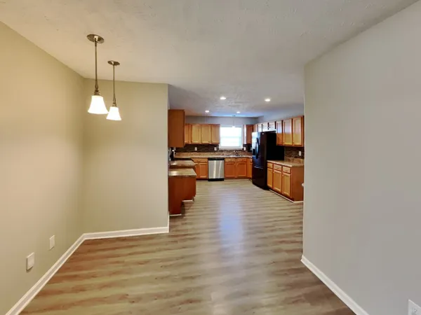 a view of a kitchen with wooden floor and a window