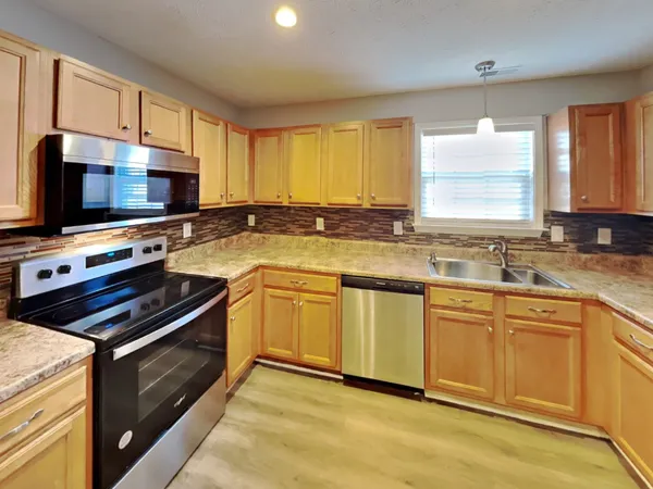 a kitchen with a sink stove top oven and microwave