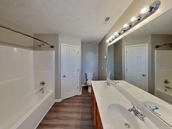 a bathroom with a tub shower and sink