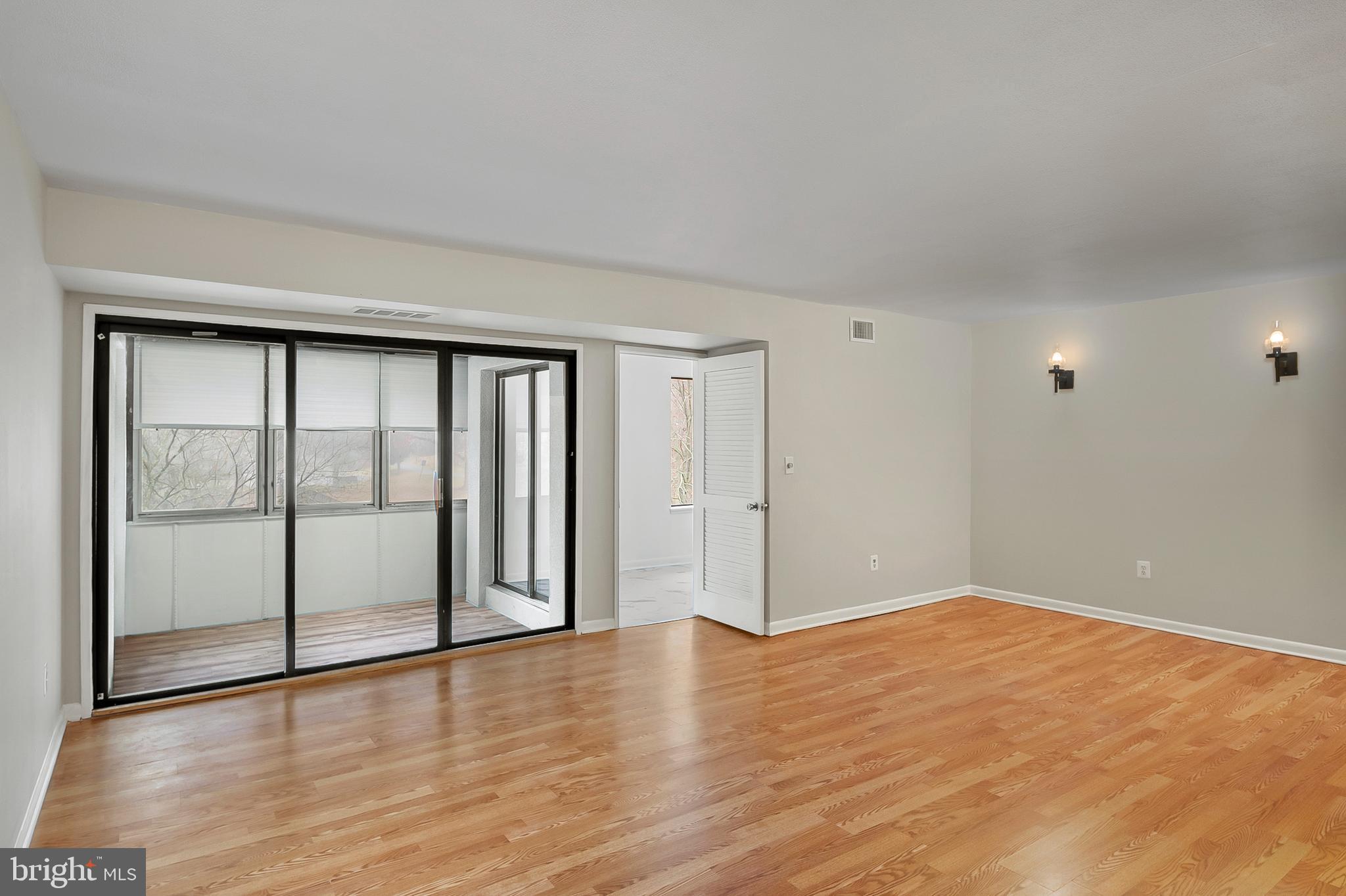 5870 Thunder Hill Road, Unit C2 Columbia, MD 21045 - Photo 3 of 23 a view of an empty room with wooden floor and a window