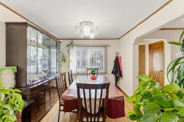 a dining room with furniture potted plants and wooden floor