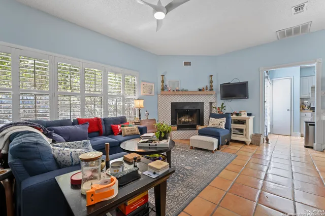 a living room with furniture a fireplace and a flat screen tv