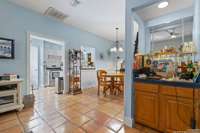a living room with furniture a dining table and a bookshelf