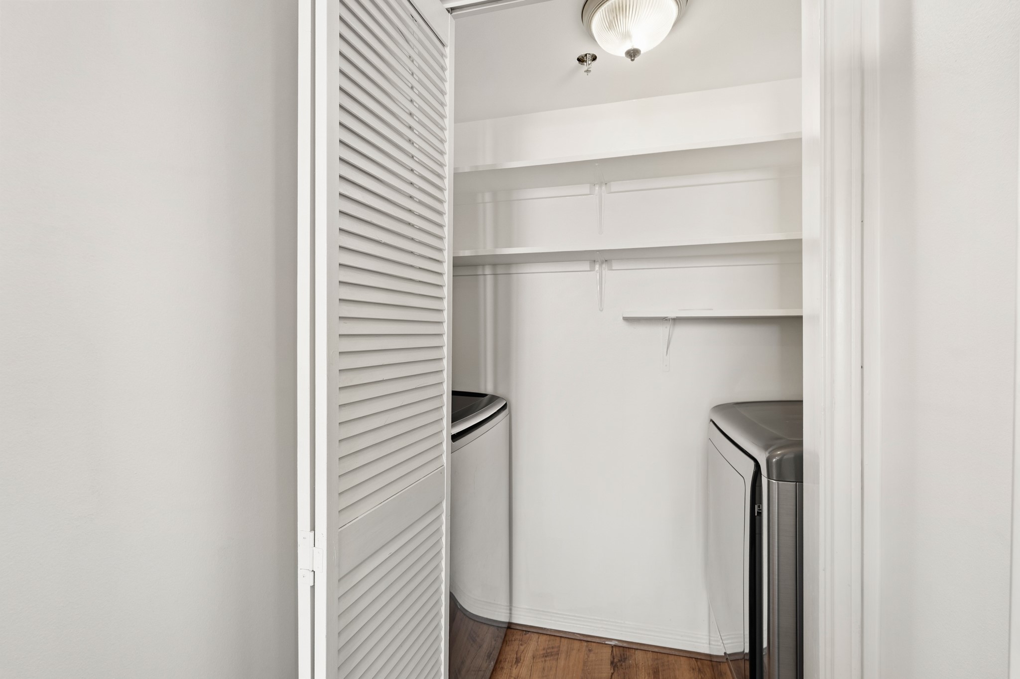 3525 Sage Road, Unit 1204 Houston, TX 77056 - Photo 19 of 25 In-unit laundry closet with washer and dryer and built-in shelving.