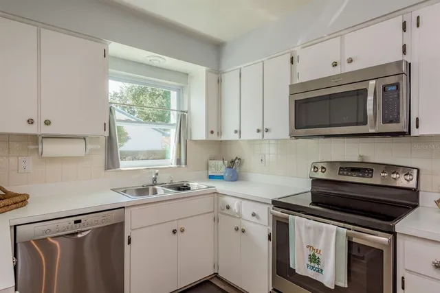 a bedroom with a bed a chair and a large window