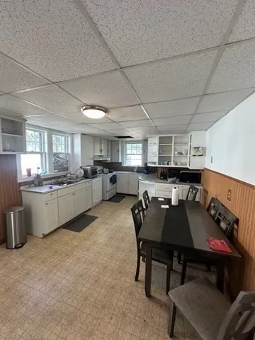 a kitchen with a table chairs microwave and cabinets