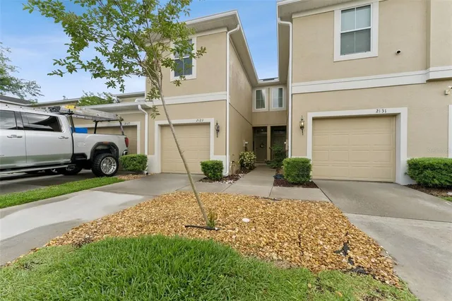 a view of a house with a yard and large tree