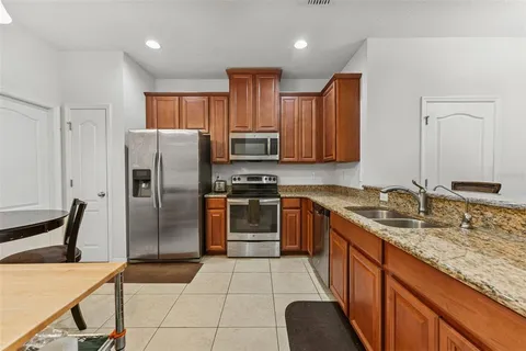 a kitchen with stainless steel appliances a stove a refrigerator and a microwave