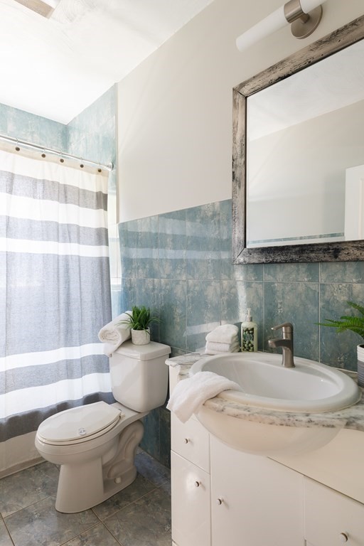 19 Riverside Street Needham, MA 02494 - Photo 10 of 18 a bathroom with a granite countertop toilet sink and mirror