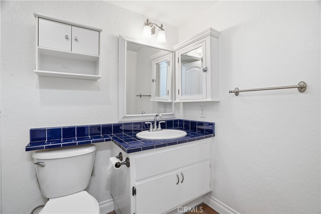 20702 El Toro Road, Unit 231 Lake Forest, CA 92630 - Photo 14 of 36 a bathroom with a granite countertop toilet sink and mirror
