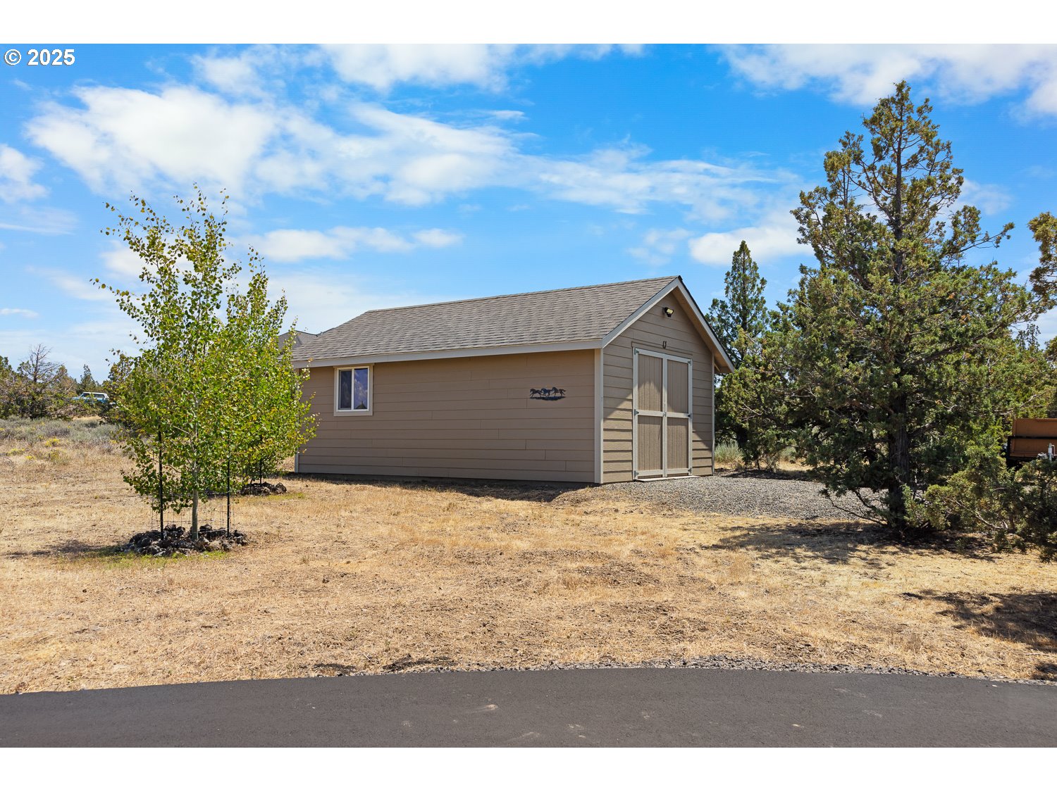 4416 Southeast Laredo Road Prineville, OR 97754 - Photo 3 of 36 a house with trees in front of it