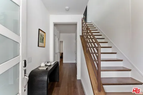 a view of hallway with stairs and wooden floor
