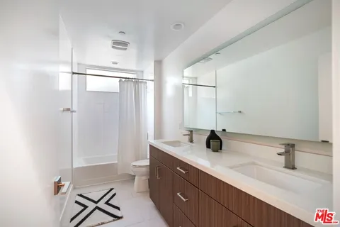 a bathroom with a double vanity sink mirror and toilet