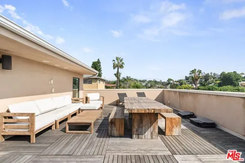 a terrace with outdoor seating and trees