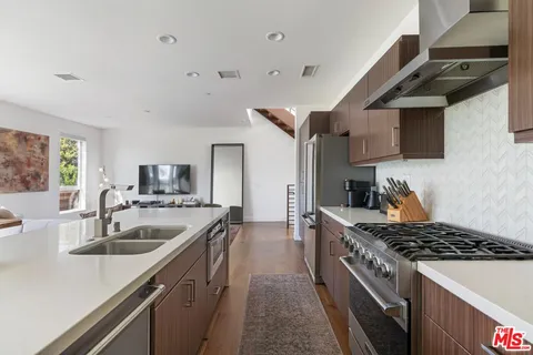 a kitchen with stainless steel appliances granite countertop a sink stove and refrigerator
