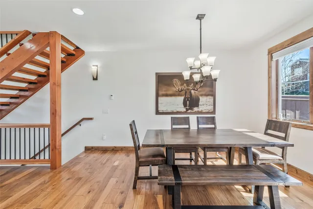 a dining room with furniture a chandelier and wooden floor