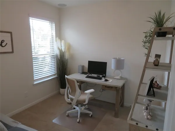 a view of a workspace with furniture and a window