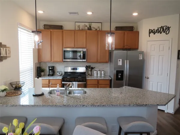 a kitchen with stainless steel appliances granite countertop a sink refrigerator and microwave
