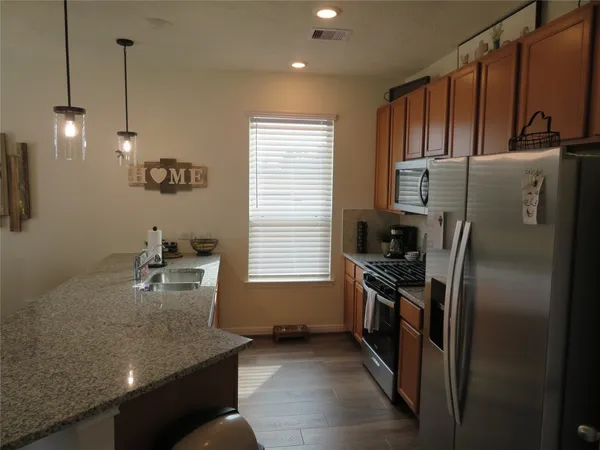 a kitchen with stainless steel appliances granite countertop a sink a stove and a refrigerator
