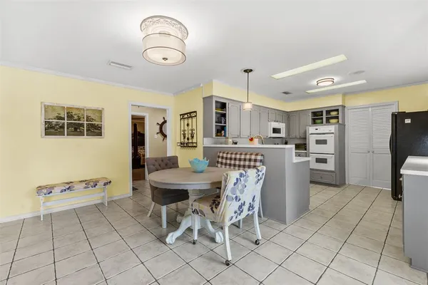 a kitchen with stainless steel appliances kitchen island granite countertop a refrigerator a stove a sink dishwasher and a dining table with wooden floor