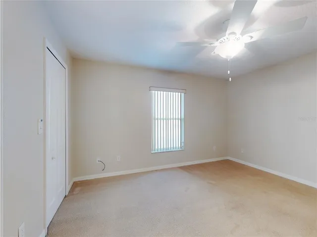 a view of a livingroom with a chandelier fan and windows