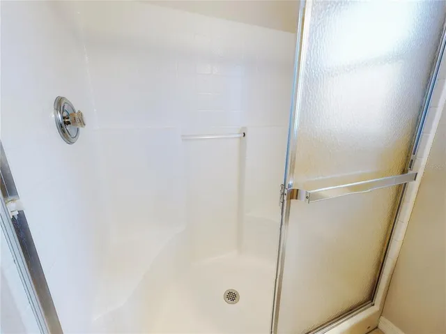 a view of swimming pool with lawn chairs and large trees