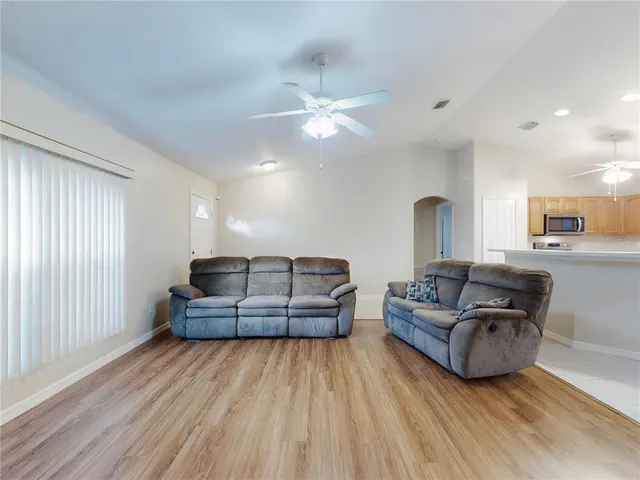 a living room with furniture and a wooden floor