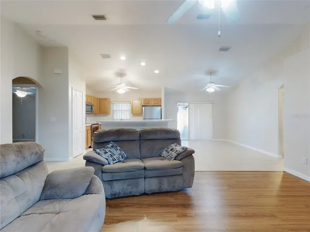 a living room with furniture and a ceiling fan