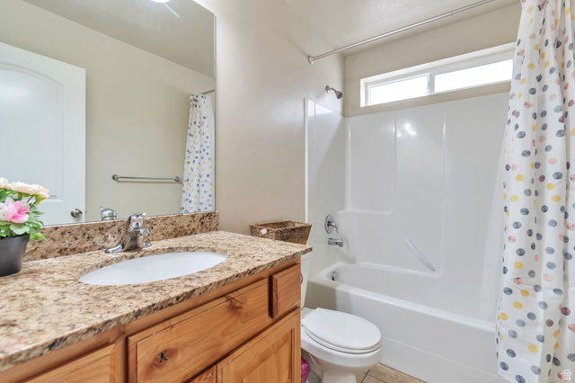 13038 Tower Ridge Drive Riverton, UT 84096 - Photo 5 of 30 Bathroom featuring a wood-finish vanity with a granite-style countertop, undermount sink, and chrome fixtures