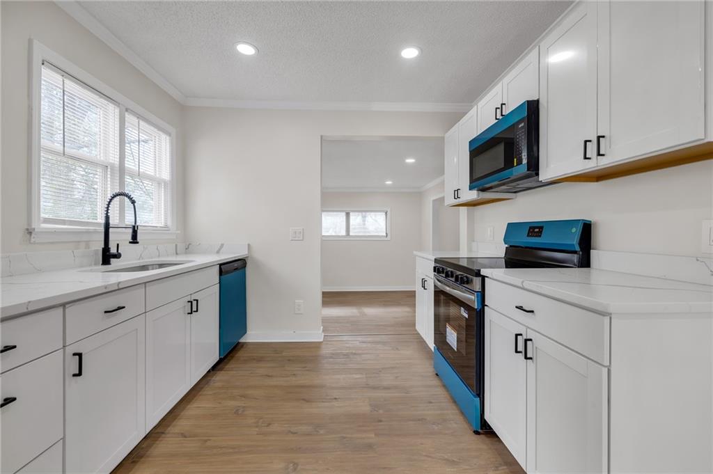 2060 Baker Road Northwest Atlanta, GA 30318 - Photo 12 of 24 a kitchen with stainless steel appliances granite countertop white cabinets a sink and a stove