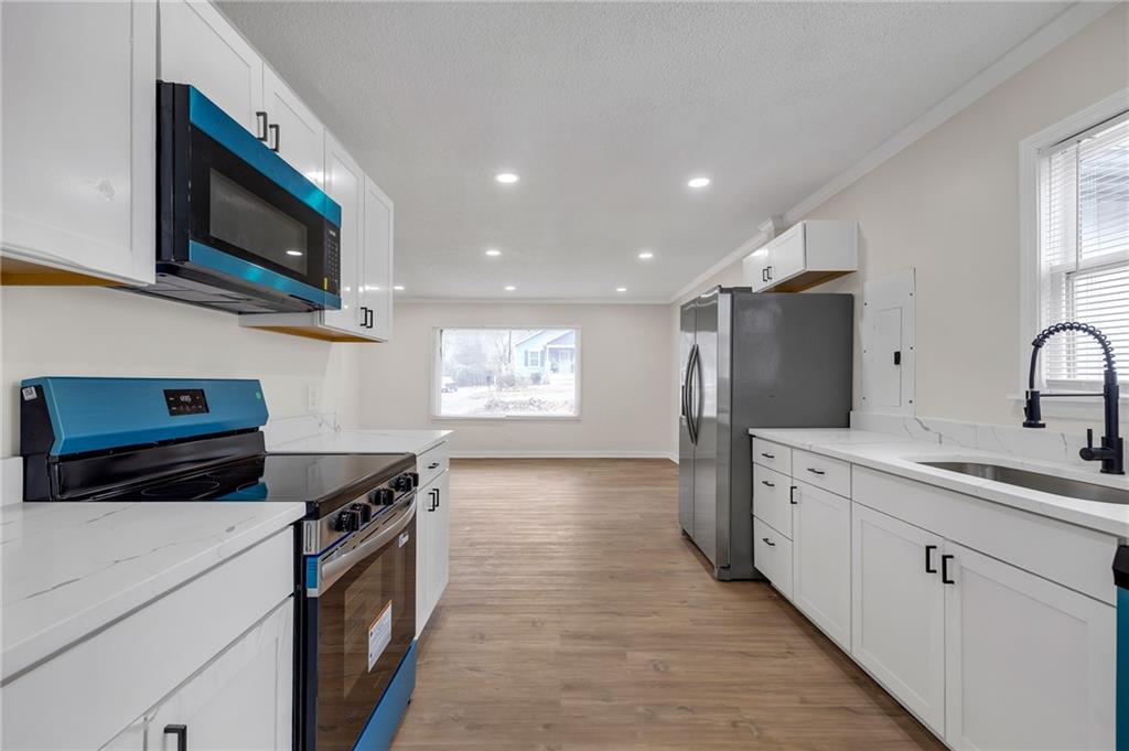 2060 Baker Road Northwest Atlanta, GA 30318 - Photo 15 of 24 a kitchen with stainless steel appliances a stove microwave and sink