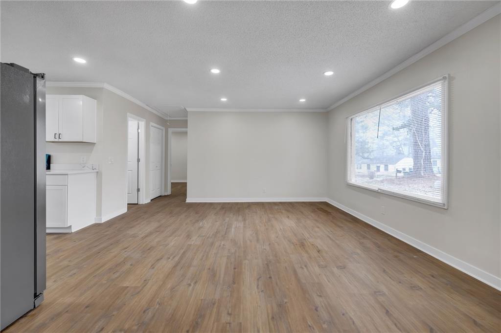 2060 Baker Road Northwest Atlanta, GA 30318 - Photo 3 of 24 a view of an empty room with wooden floor and a window