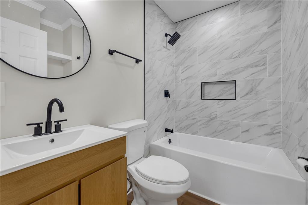 2060 Baker Road Northwest Atlanta, GA 30318 - Photo 7 of 24 a bathroom with a sink a toilet and a mirror