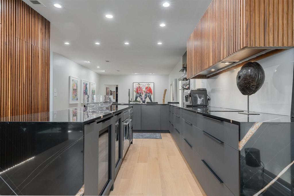 3731 Gilbert Avenue, Unit 3 Dallas, TX 75219 - Photo 11 of 40 a kitchen with stainless steel appliances granite countertop a sink a stove top oven a counter space and cabinets
