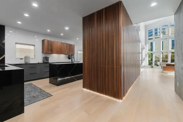 a living room with stainless steel appliances kitchen island granite countertop a refrigerator and a sink