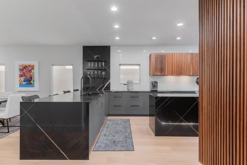 3731 Gilbert Avenue, Unit 3 Dallas, TX 75219 - Photo 5 of 40 a kitchen with kitchen island a counter top space a sink a stove and cabinets