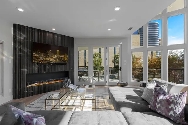 a living room with furniture a large window and a fireplace