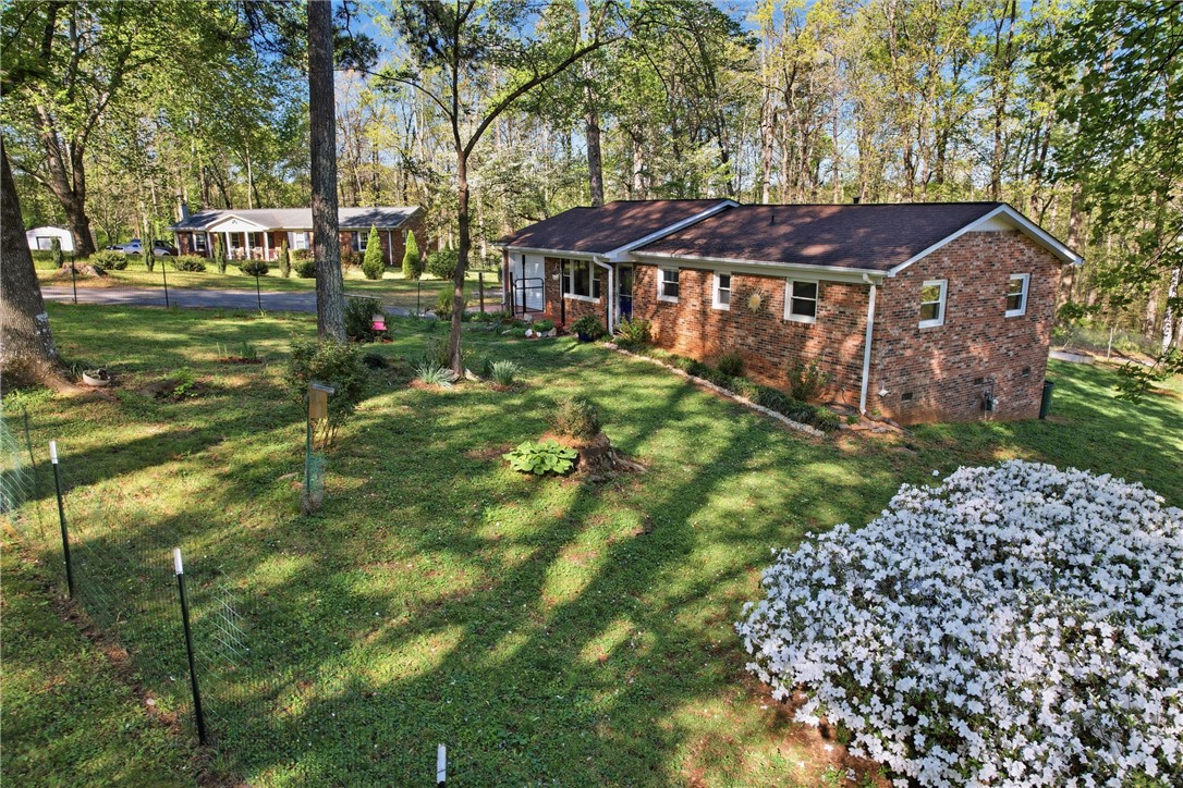 623 West Springwood Drive Seneca, SC 29672 - Photo 29 of 50 This charming brick residence is nestled in a serene, tree-lined setting, offering a peaceful retreat.